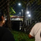 Unas mujeres miran a través de una valla durante una vigilia para exigir la liberación de los presos políticos venezolanos frente a la prisión El Rodeo I en Guatire.