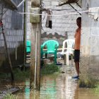 Un morador permanece dentro de su vivienda, rodeado por el agua acumulada tras las fuertes lluvias que afectaron a La Unión, en Quinindé.