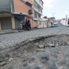 Los baches y el desgaste del asfalto obligan a los conductores a reducir la velocidad y cambiar de trayectoria para continuar por las calles del sector.
