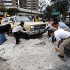 Ciudadanos colaboraron en el retiro del hielo acumulado sobre los vehículos que quedaron cubiertos por la fuerte granizada registrada en Quito.