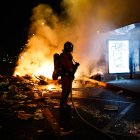 Un bombero francés interviene ante barricadas en llamas en una calle.