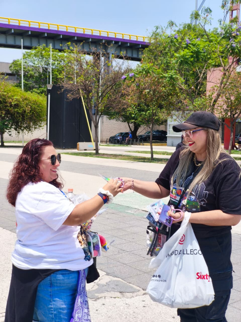 Las fanáticas de BTS intercambian recuerdos antes de ingresar al recinto.